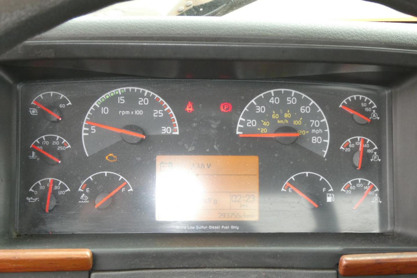 Dashboard of a Volvo VNM42T truck showing multiple gauges and an orange digital display.