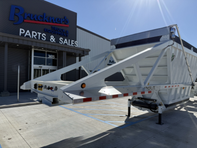 Trailer body showing Armor Lite SBD40 spring skeleton dump trailer with metal frame and landing gear in front, at Bruckner's Parts & Sales.