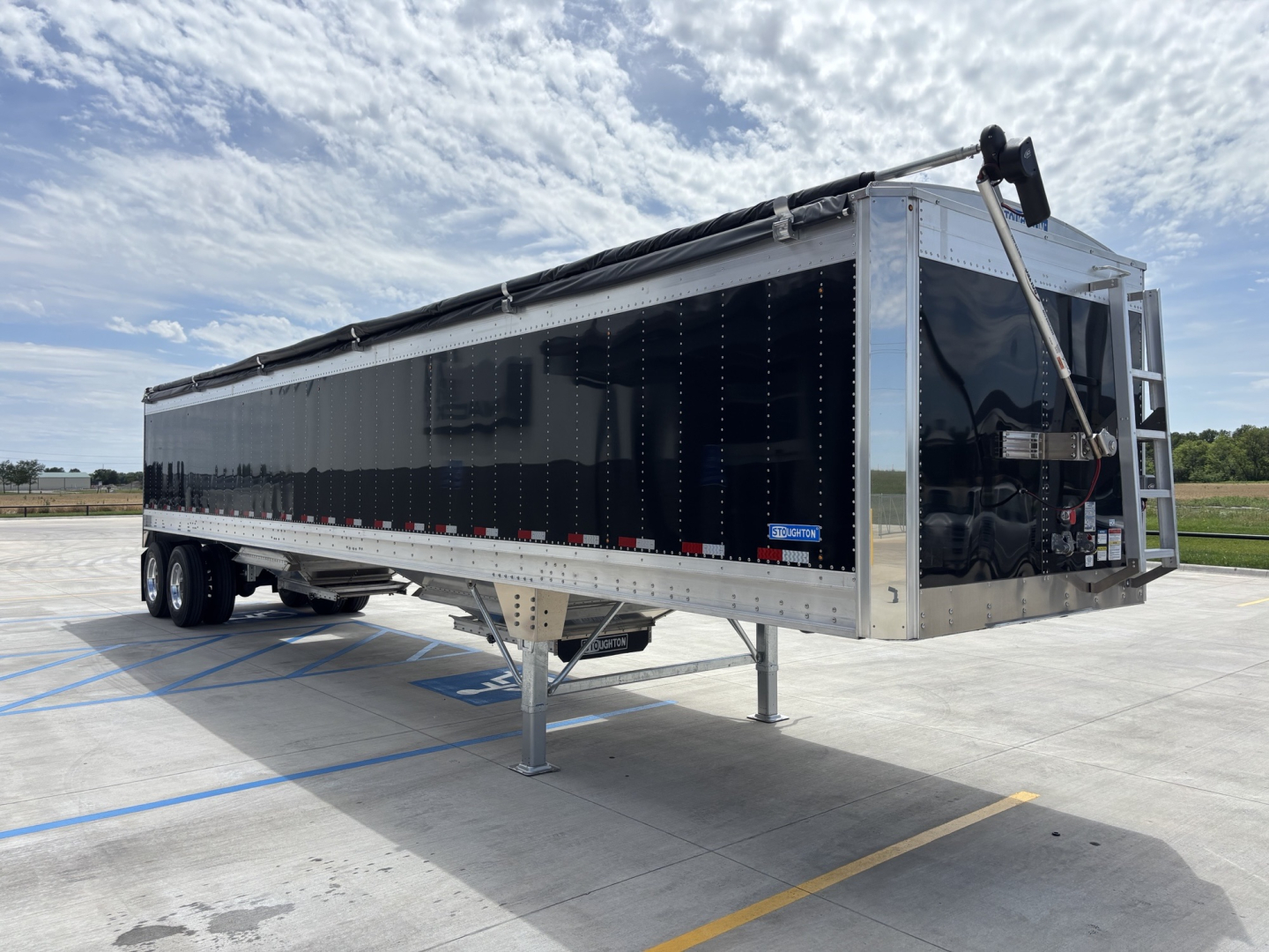 Stoughton 42 foot aluminum grain hopper trailer with 74 inch sides, black side panels, front gooseneck, dual axles, and landing gear.