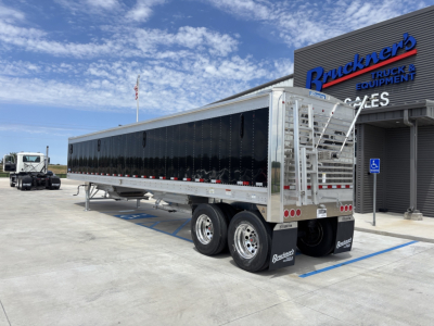 Trailer showing 42' aluminum grain hopper with 74-inch side walls, dual rear axles, black side panels, aluminum ladder and rear frame.