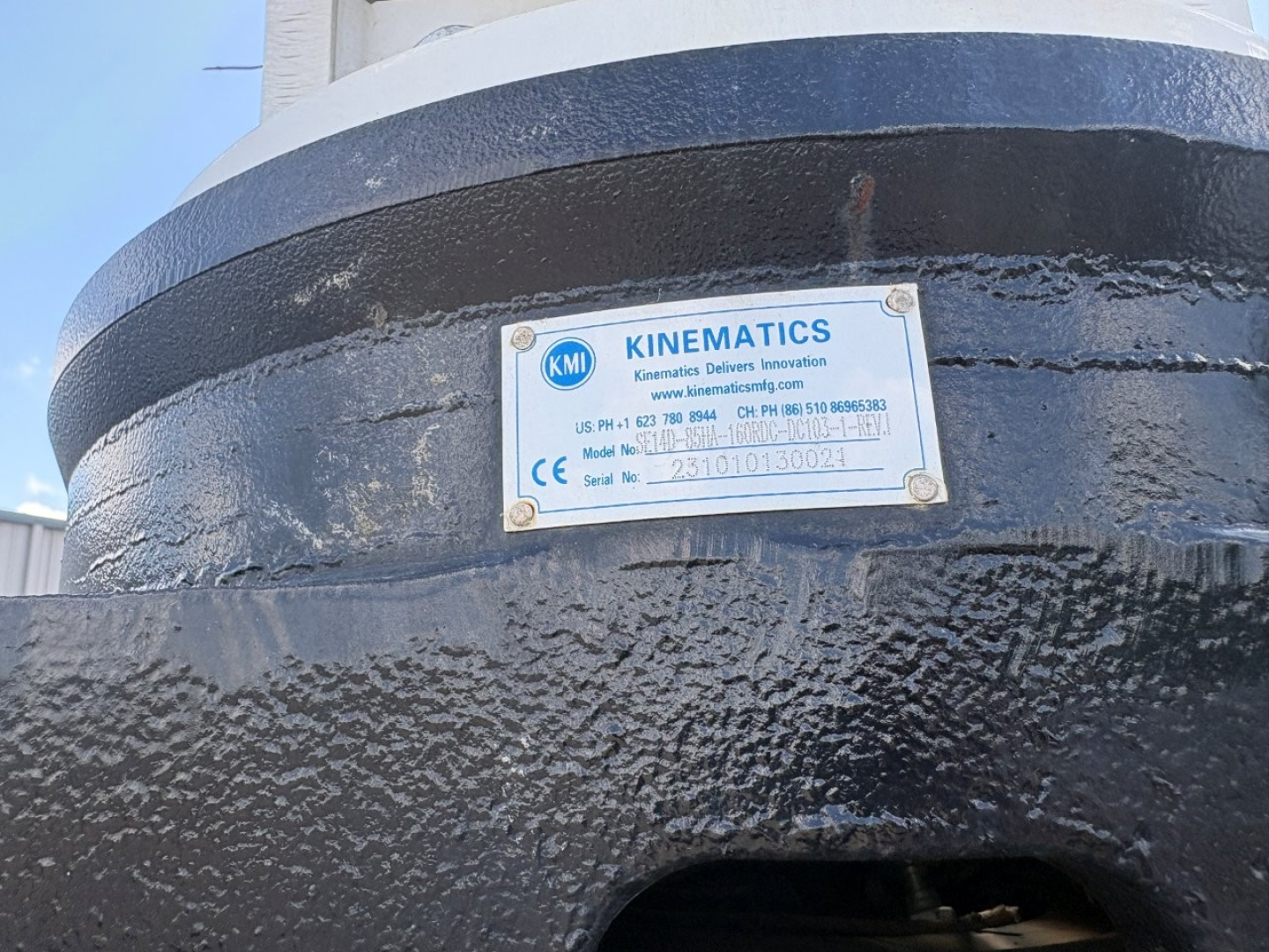 Kinematic label on a black cylindrical tank showing KINEMATICS brand plate with model and serial numbers.