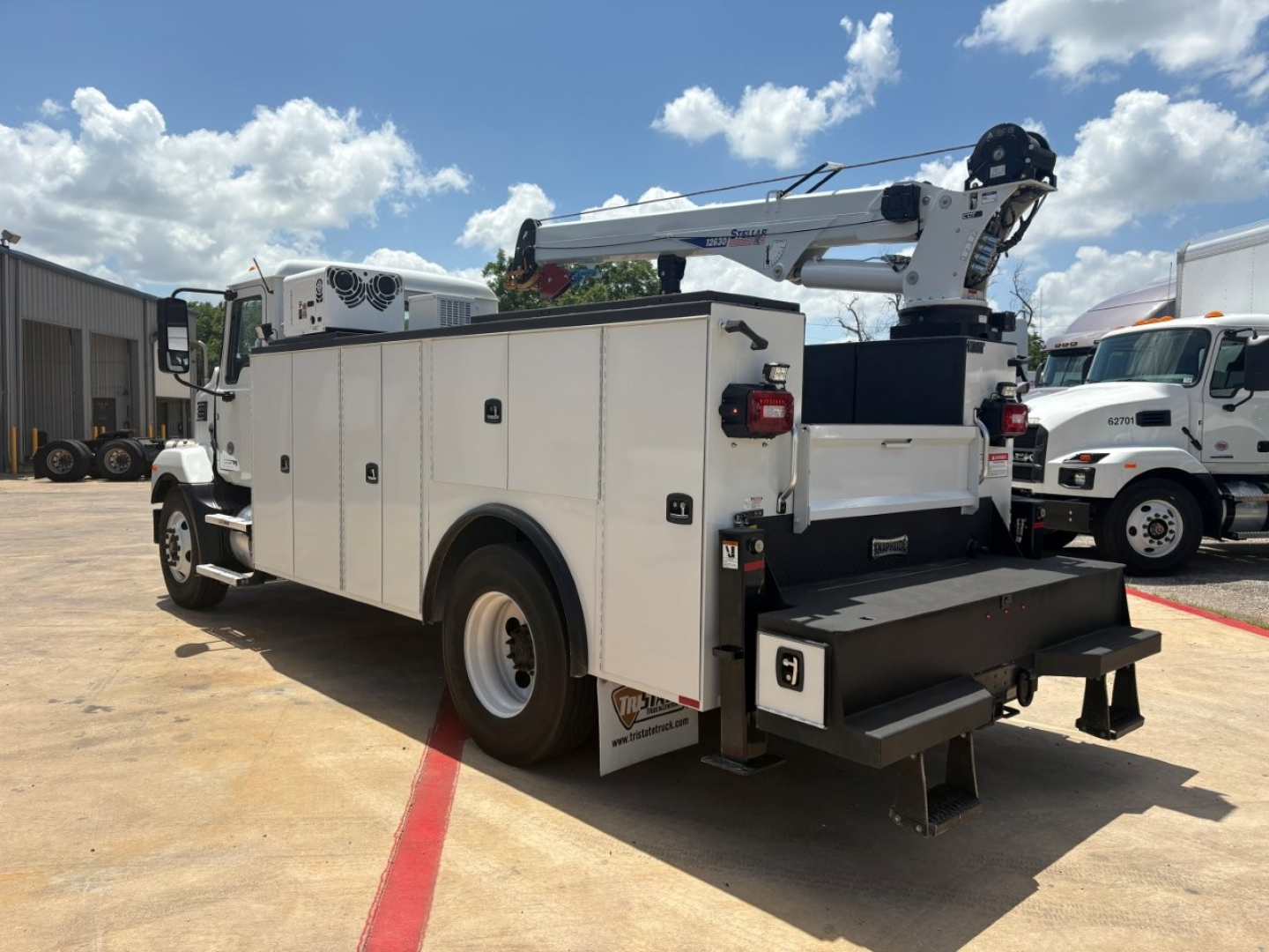 Mack MD6 service truck with crane arm and tool compartments, side view showing utility body, rear fold-out steps, and ladder rack.