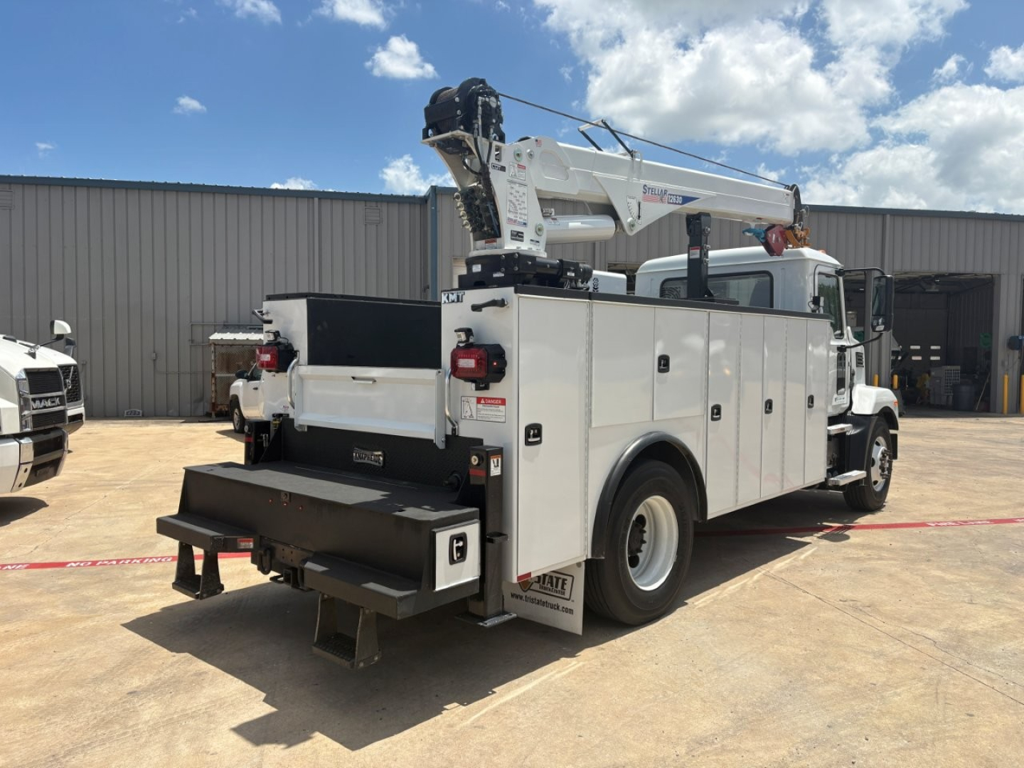 Mack MD6 service/utility truck in-service showing utility body with crane, rear storage compartments, and ladder rack.