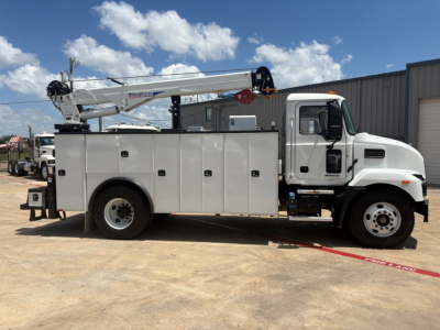 Service/utility truck with a mounted aerial boom crane lengthwise view showing compartments, cab and wheel, 2024 Mack MD6.