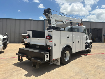 Mack MD6 service/utility truck in-service showing utility body with crane, rear storage compartments, and ladder rack.