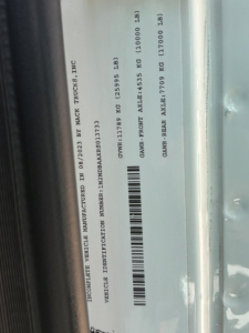 Vehicle identification label on Mack MD6 chassis showing VIN 1M2MDBAAXRS013733, GVR weight ratings, axle weights, and identification bar code.