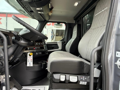New Western Star 47X truck cab interior showing driver seat and controls with gray upholstery and diamond stitching.