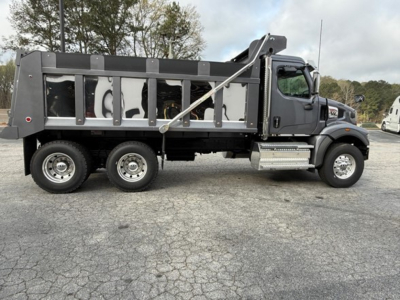 Western Star 47X dump truck side profile showing dump bed, cab, dual rear wheels, and hydraulic hoist with frame-mounted steps.