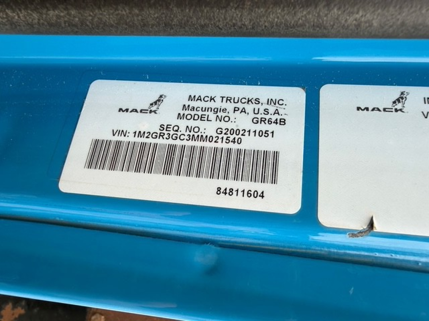 Mack Trucks label on blue body showing Mack Trucks, Inc. Macungie, PA, USA. MODEL NO.: GR64B, SEQ. NO.: G200... VIN: 1M2GR3GC3MM021540 and barcode 84811604.