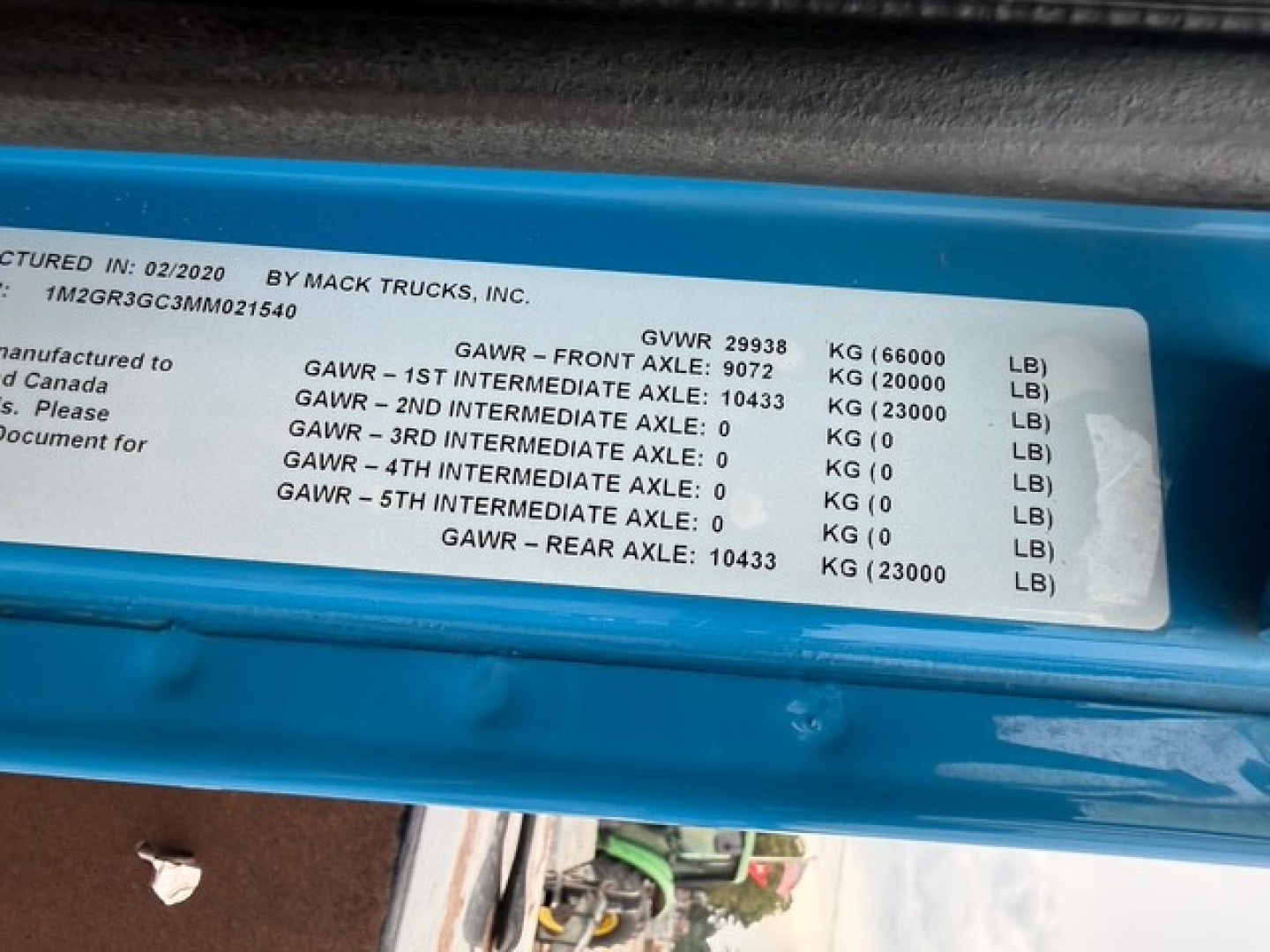 Label showing GVWR 29938 kg, GAWR front 9072 kg, GAWR rear 10433 kg, and 1M2GR3GC3MM021540 VIN on a blue frame plate.