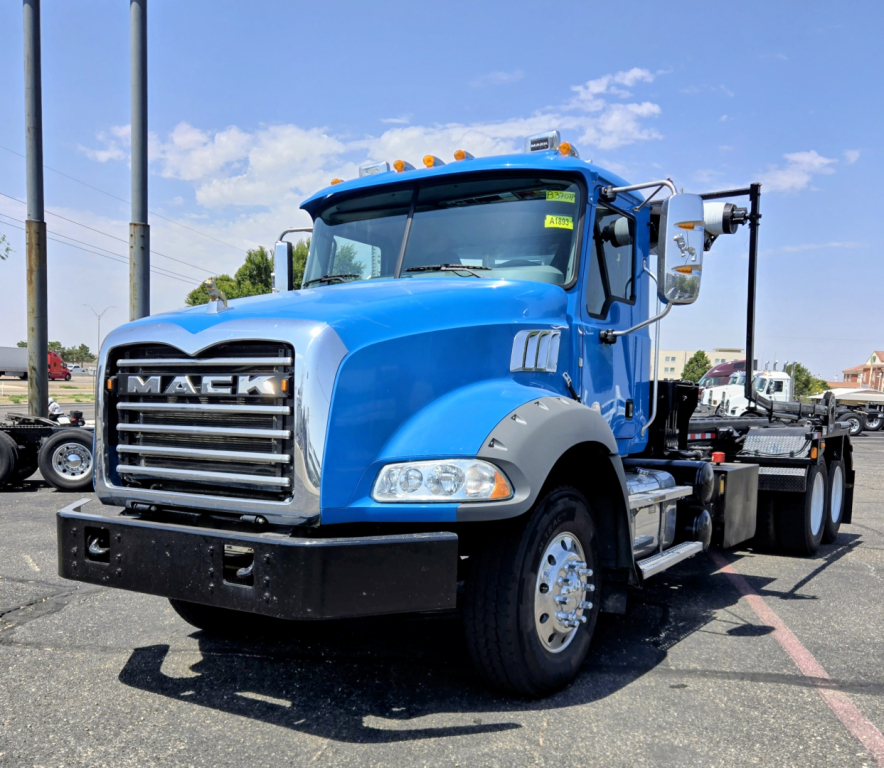 Mack GR64B truck in blue showing front grille and side view with bumper and wheel.