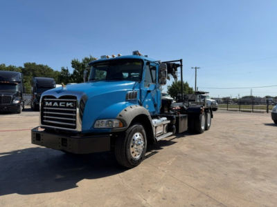 Blue 2021 Mack GR64B truck with flatbed chassis, front view showing Mack grille, headlights, and large bumper.