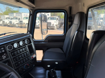 Cab interior of a 2021 Mack GR64B rolloff truck showing driver's seat and dashboard with multiple gauges and controls.
