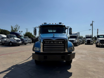 Front view of a blue 2021 Mack GR64B roll-off truck showing grille with MAC K lettering and bumper.