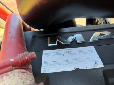 Mack engine bay showing stamped label and cables on top of engine cover.