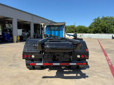 Back view of a 2021 Mack GR64B roll-off truck showing rear bumper, taillights, and hitch assembly.