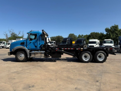Blue Mack GR64B rolloff truck side view showing chassis and cab with long wheelbase and dual rear axles.