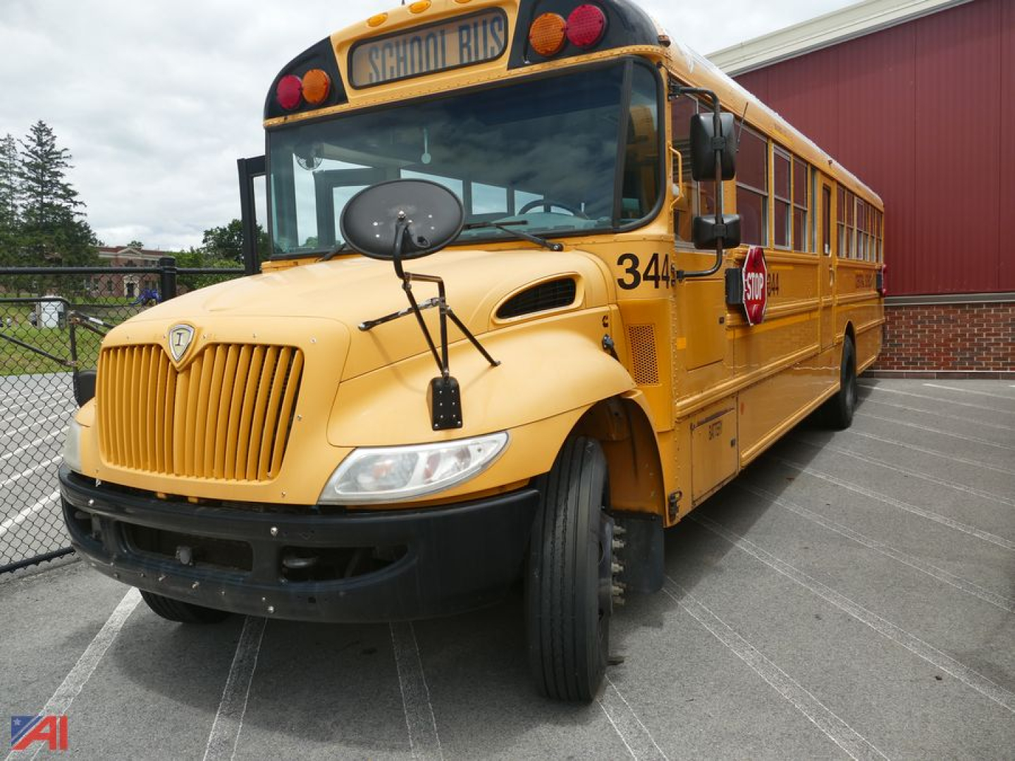 School bus with yellow body showing front grille, black bumper, round mirrors, and 'CHNUL BUS' sign; bus number 34 on door, side loading door, yellow warning lights.