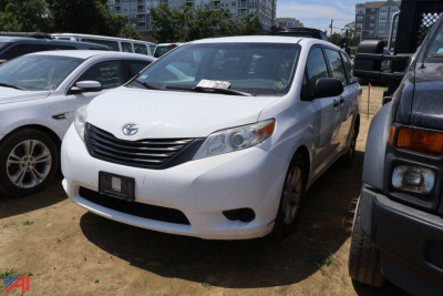 White 2017 Toyota Sienna minivan in a used vehicle lot, front three-quarter view with Toyota emblem and grille visible.