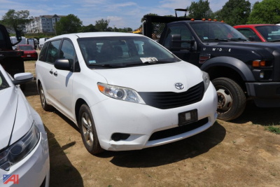 Toyota Sienna minivan in white showing front grille and headlights.