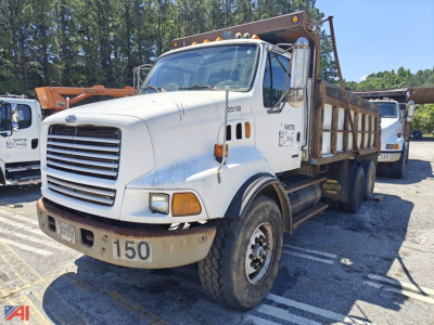 Dump truck in service showing front and side view with a white cab and dump bed, Sterling LT9500 series; number 150 on bumper and faded markings on door.