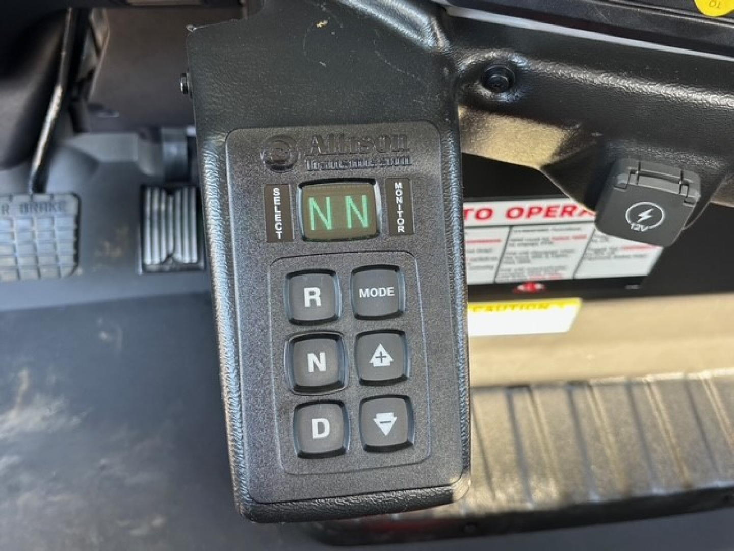 Mack MD7 vehicle lever/shifter panel showing transmission mode buttons R N D and plus/minus icons with ‘AUTO’ label and green LN indicators.