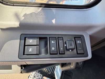 MD7 cab interior switch panel showing window controls, mirror adjustment, and headlight/auxiliary switch layout.