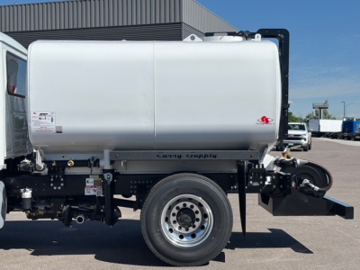 Side view of a 2026 Mack MD7 concrete mixer truck showing a large silver mixer drum mounted on a chassis with a single rear wheel and hydraulic system; visible labels and safety decals on the drum.
