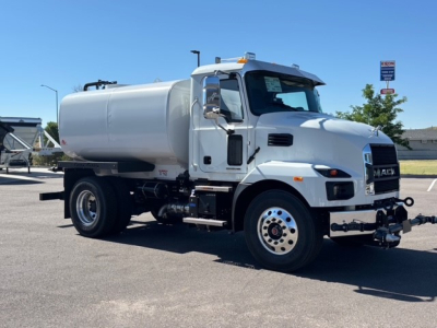 Truck: 2026 Mack MD7 vacuum/ tanker with large cylindrical tank mounted on chassis, side view showing front grille and wheels.