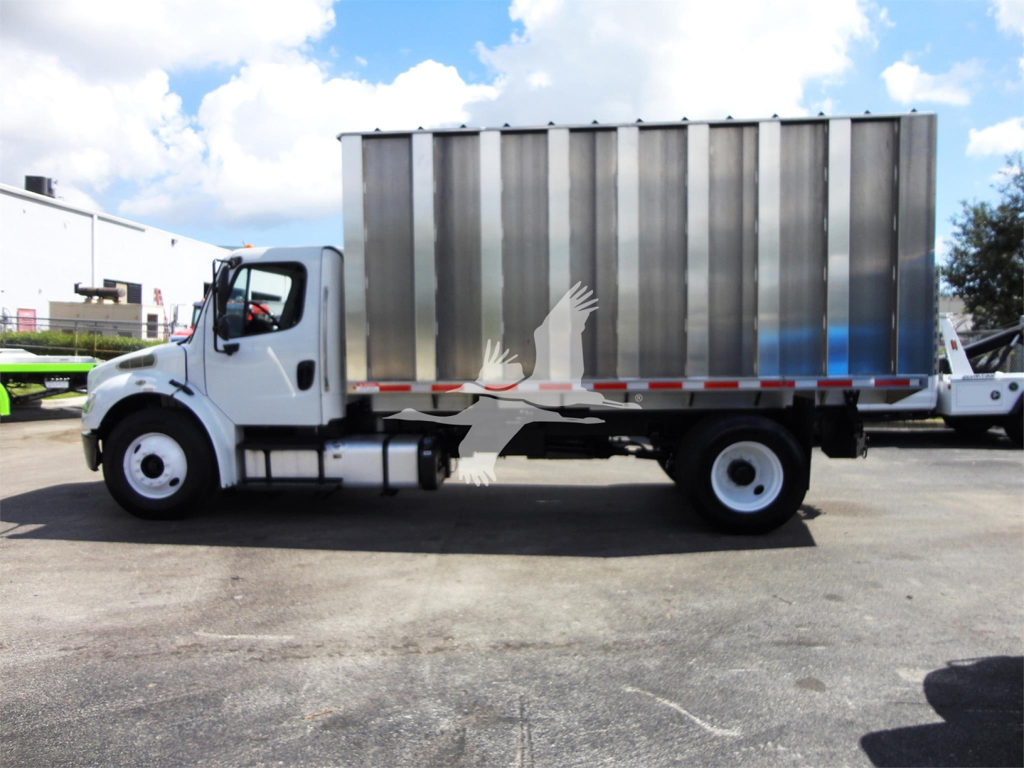 Truck side view of 2014 Freightliner M2 106 chipper bed with silver dump body, white cab, flat ground, clear sky.