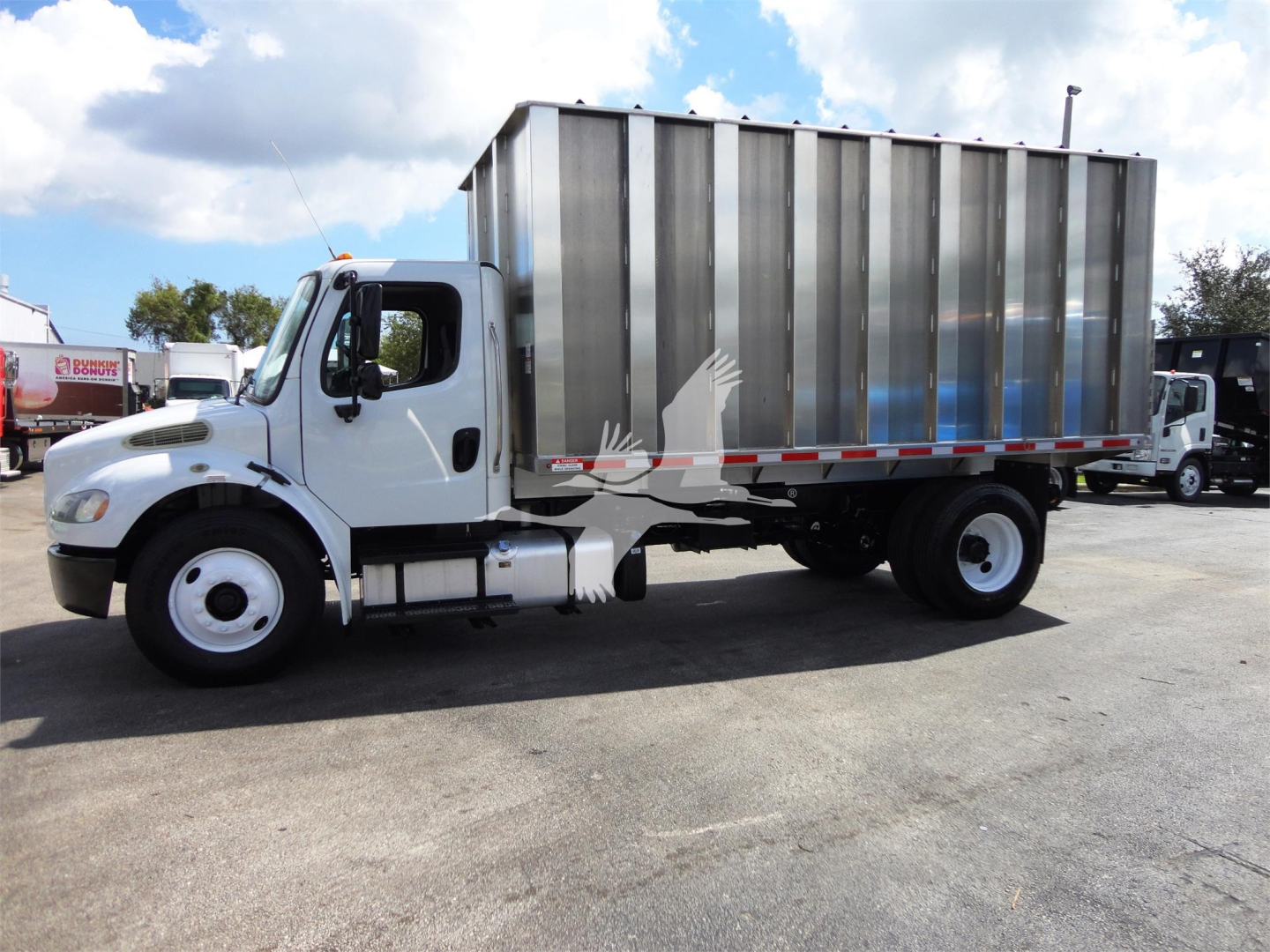 Freightliner M2 106 cab with large steel cargo container in side view.