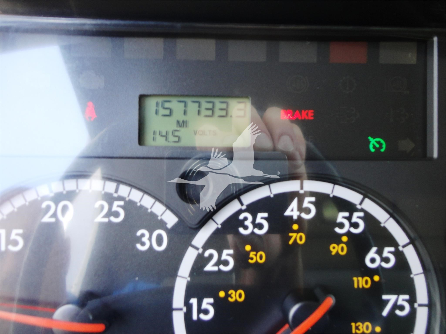 Dashboard and instrument cluster of a Freightliner M2 106 showing odometer reading 157733.3 miles and various gauges.