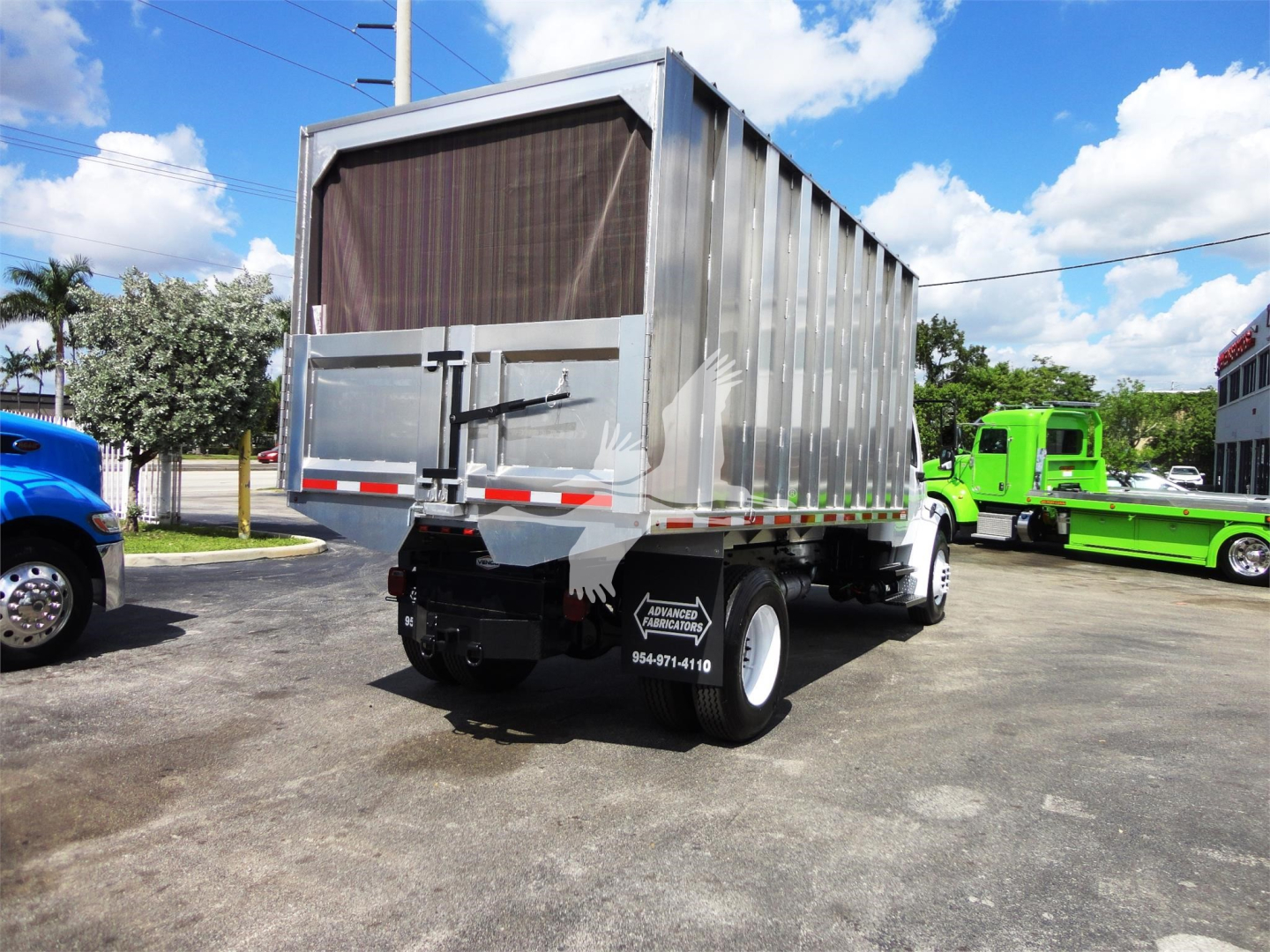 Truck rear view of a 2014 Freightliner M2 106 dump bed with mesh rear gate and black rear bumper, visible stock number 183002R.
