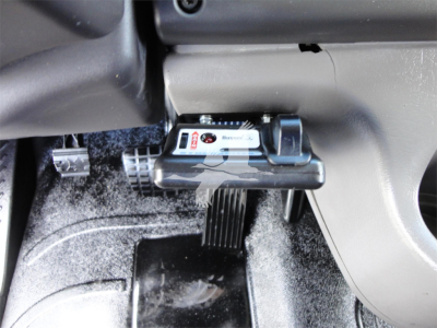 Cab area of a Freightliner M2 106 interior showing dash controls and accelerator pedal with label visible.