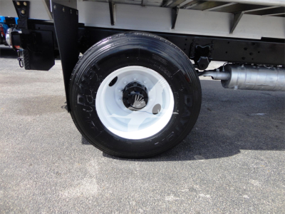 Truck wheel close-up showing white steel rim and black tire on Freightliner M2 106 chassis side view.