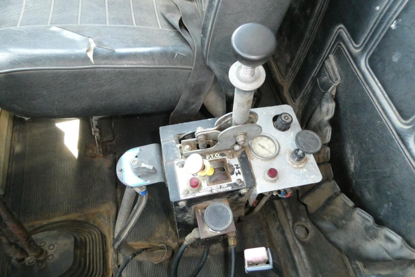 Cockpit panel with joystick shift lever and multiple gauges in a Mack RD690S cab interior showing control console and levers.