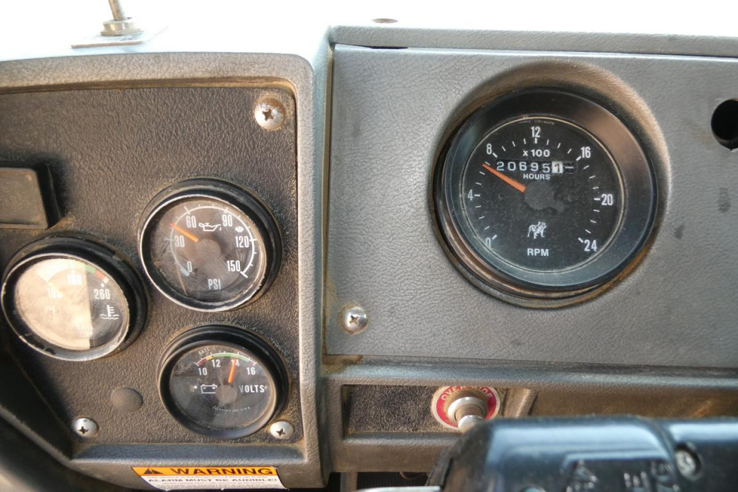 Dashboard and instrument gauges in a Mack RD690S cab showing RPM gauge and multiple dials