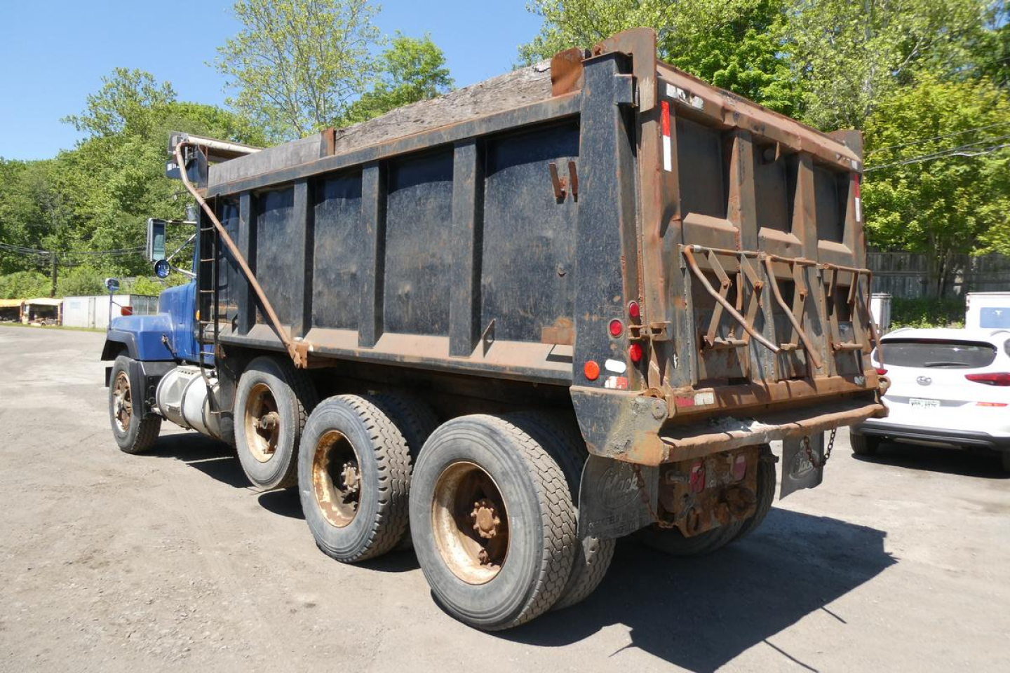 Dump truck bed of a 1998 Mack RD690S with a black, rectangular dump body and dual rear wheels, viewed from the left-rear angle.
