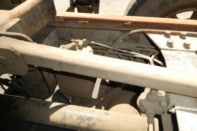 Mack RD690S truck chassis view showing diesel exhaust cooler and frame components with wiring harness and hoses.