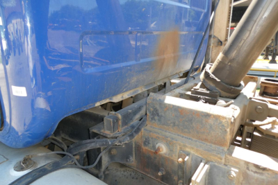 Truck chassis area of a Mack RD690S showing hydraulic hitch and frame with rust-inch details.