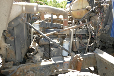 Mack RD690S engine bay showing various hoses, metal pipes, and cylindrical filters in a dusty, in-service condition.