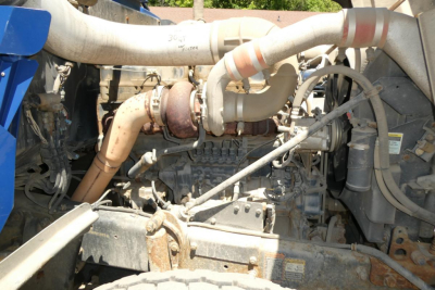 Mack RD690S truck engine bay showing turbocharger, exhaust manifold, and various hoses.