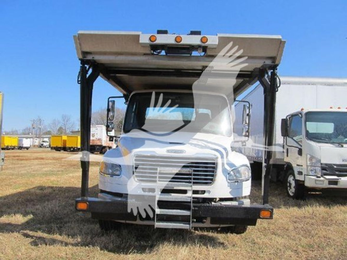 Front view of a 2019 Freightliner M2 106 auto carrier truck with a raised bed, large bumper, and ladder access, VIN 1FVACXFEXKHKD5405 visible in listing context.