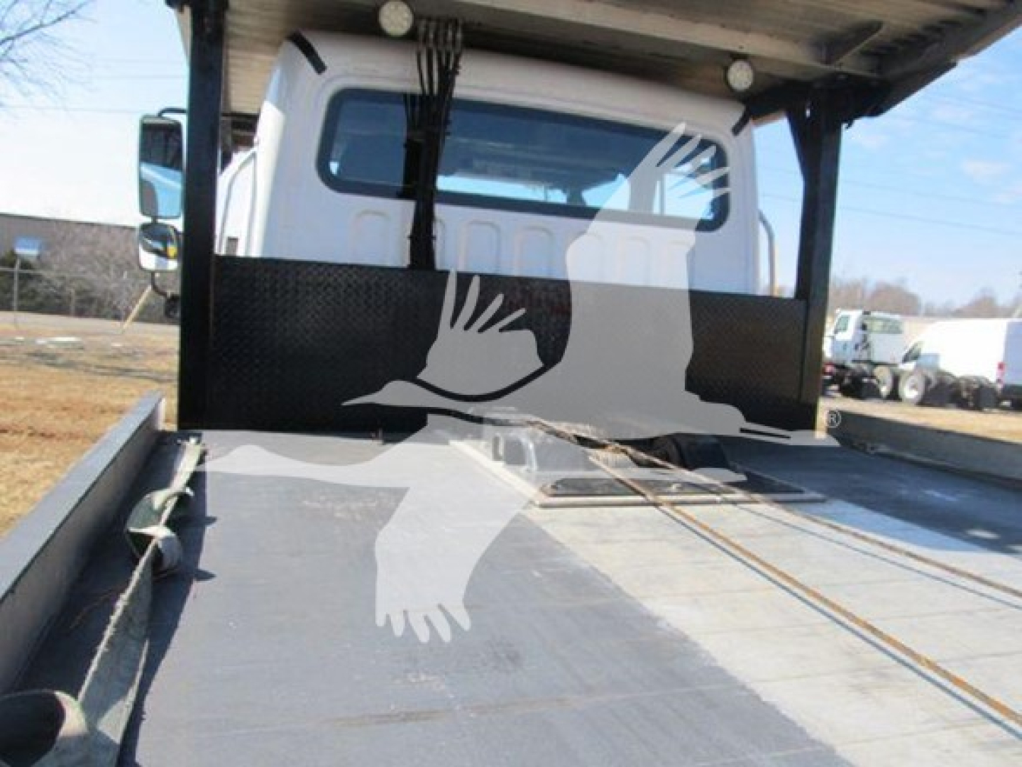 Truck bed of 2019 Freightliner M2 106 with flatbed equipment and rear cab view