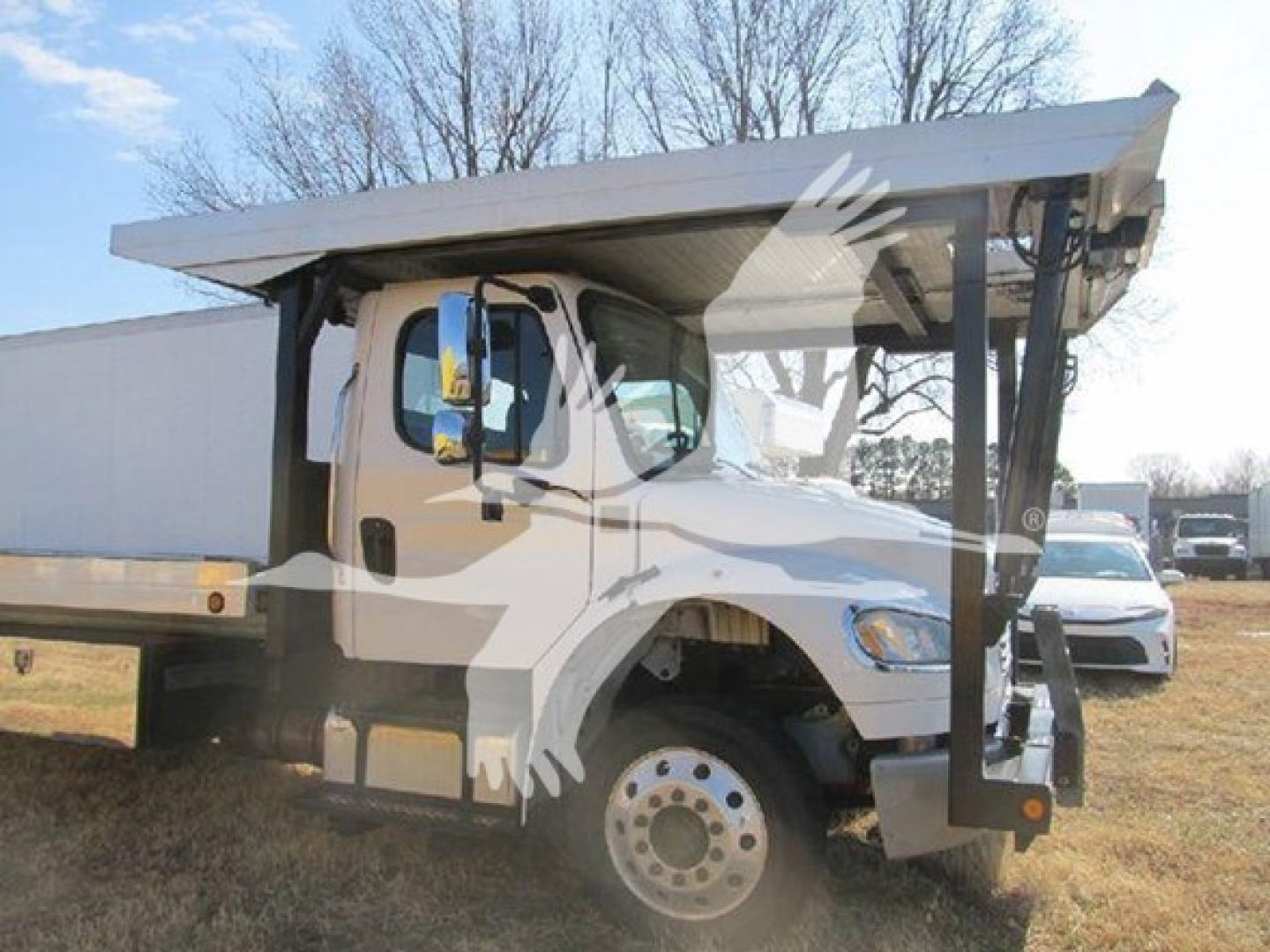 Truck cab with dump bed showing Freightliner M2-106 auto carrier components and chassis details.