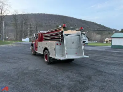1980 International S1824 pumper fire truck rear/side view with mounted ladders and aluminum diamond plate compartments.