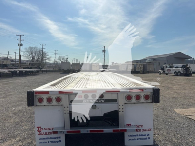Front view of a 2015 Benson flatbed trailer showing rear end with taillights, bumper, and Benson branding; VIN plate not visible; outdoor lot with other trailers.