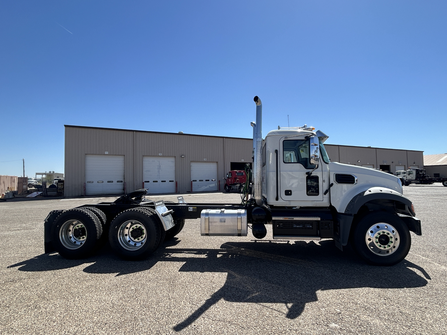 2027 Mack GR64FT tractor cab side view showing crew cab, dual rear axles, fuel tank, and exhaust stack.