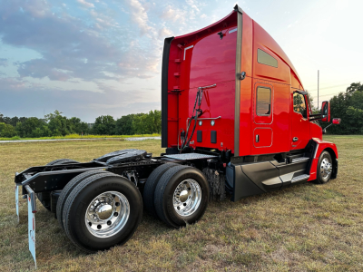 Kenworth T680 tractor cab and chassis showing rear view with dual rear axles and red sleeper cab.