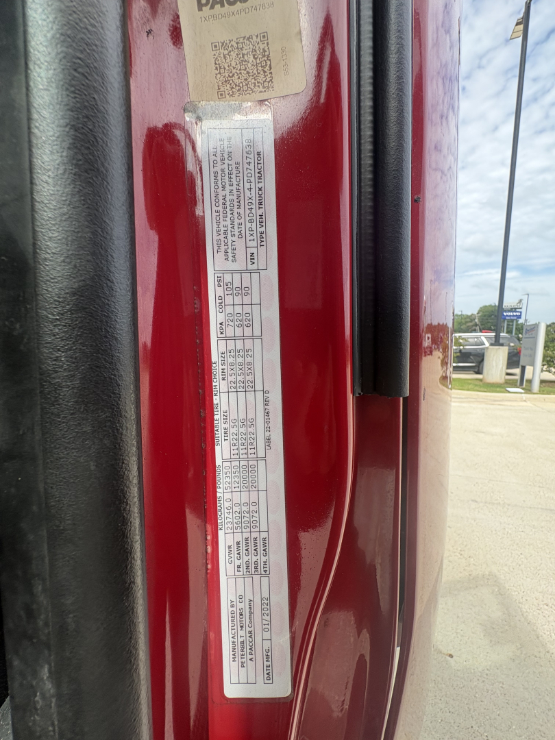 Vertical label on red Peterbilt door jamb with multiple lines of small text including VIN and weight specifications.